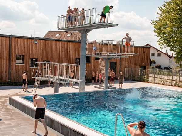 Badegäste am Sprungturm des Freibads