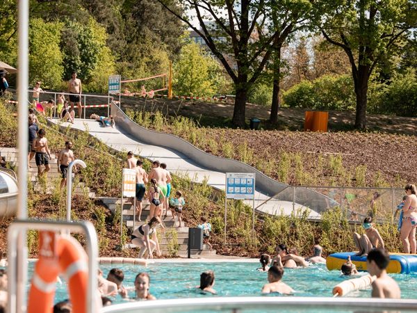 Badegäste an der Rutsche und im Becken
